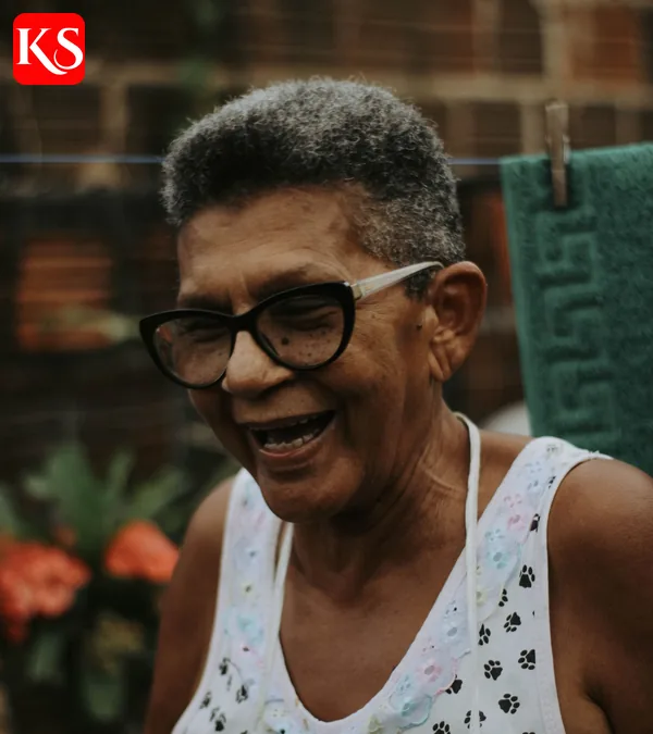 Lächelnde Seniorin mit Brille im Gespräch – gesundes Altern und Longevity