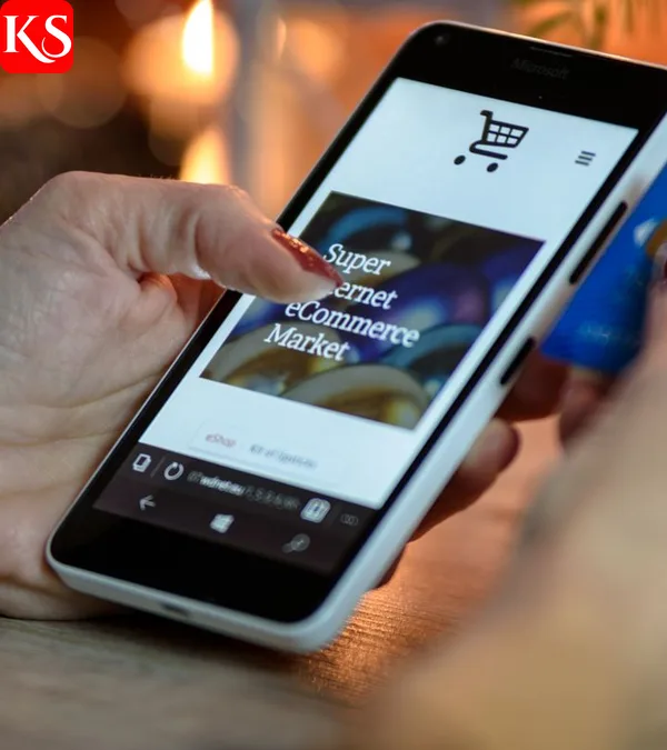 Mit dem Smartphone am Prime Day 2026 einkaufen: Einkaufswagen-Symbol auf dem Display und Kreditkarte in der Hand