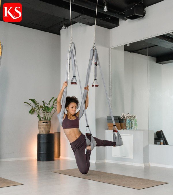 Frau beim Bungee Fitness im Studio – schwebende Übung am elastischen Seil